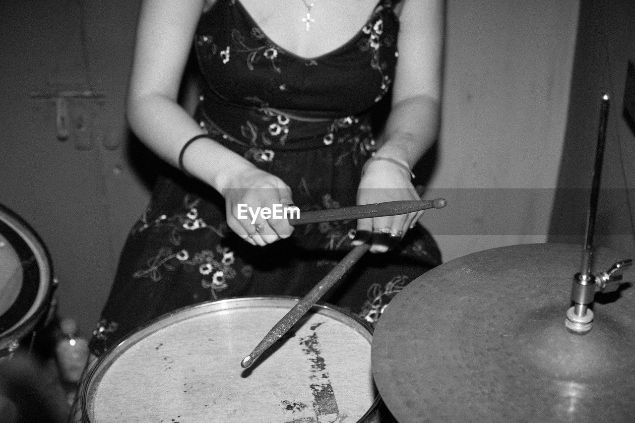 High angle view of the midsection of a person playing drums.