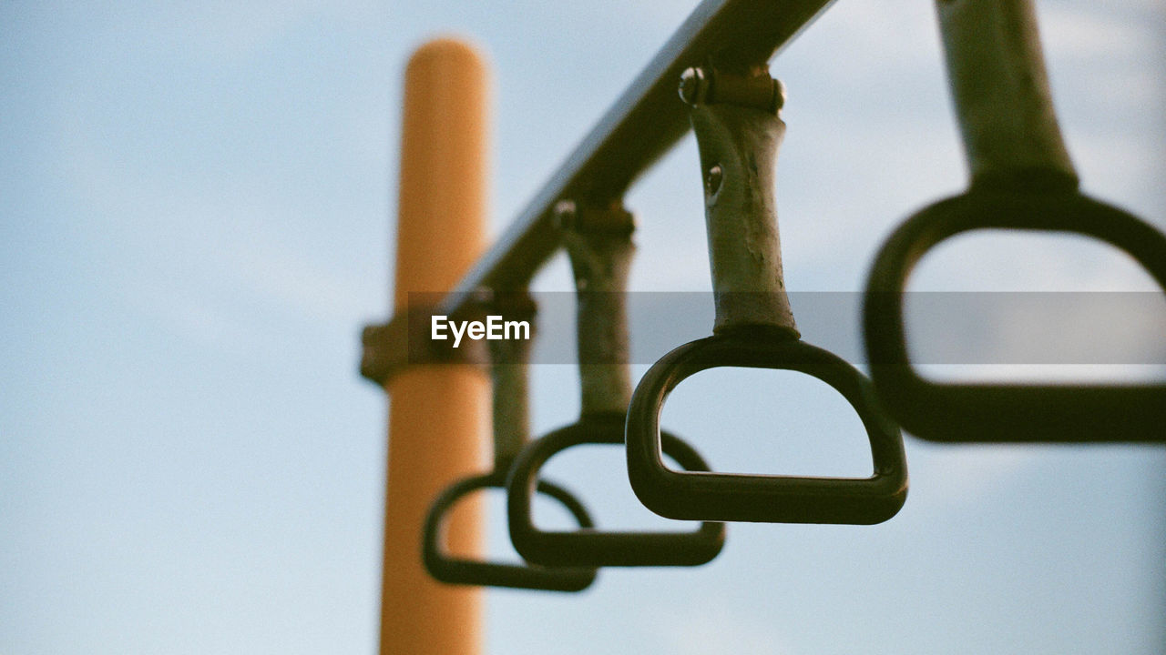 Low angle view of metallic handle against sky