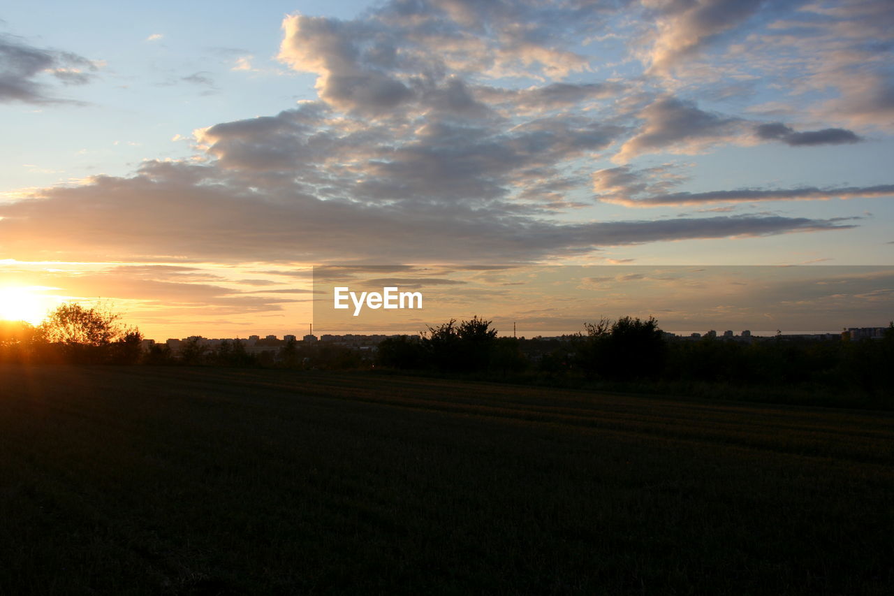 SCENIC VIEW OF AGRICULTURAL FIELD AGAINST SKY DURING SUNSET