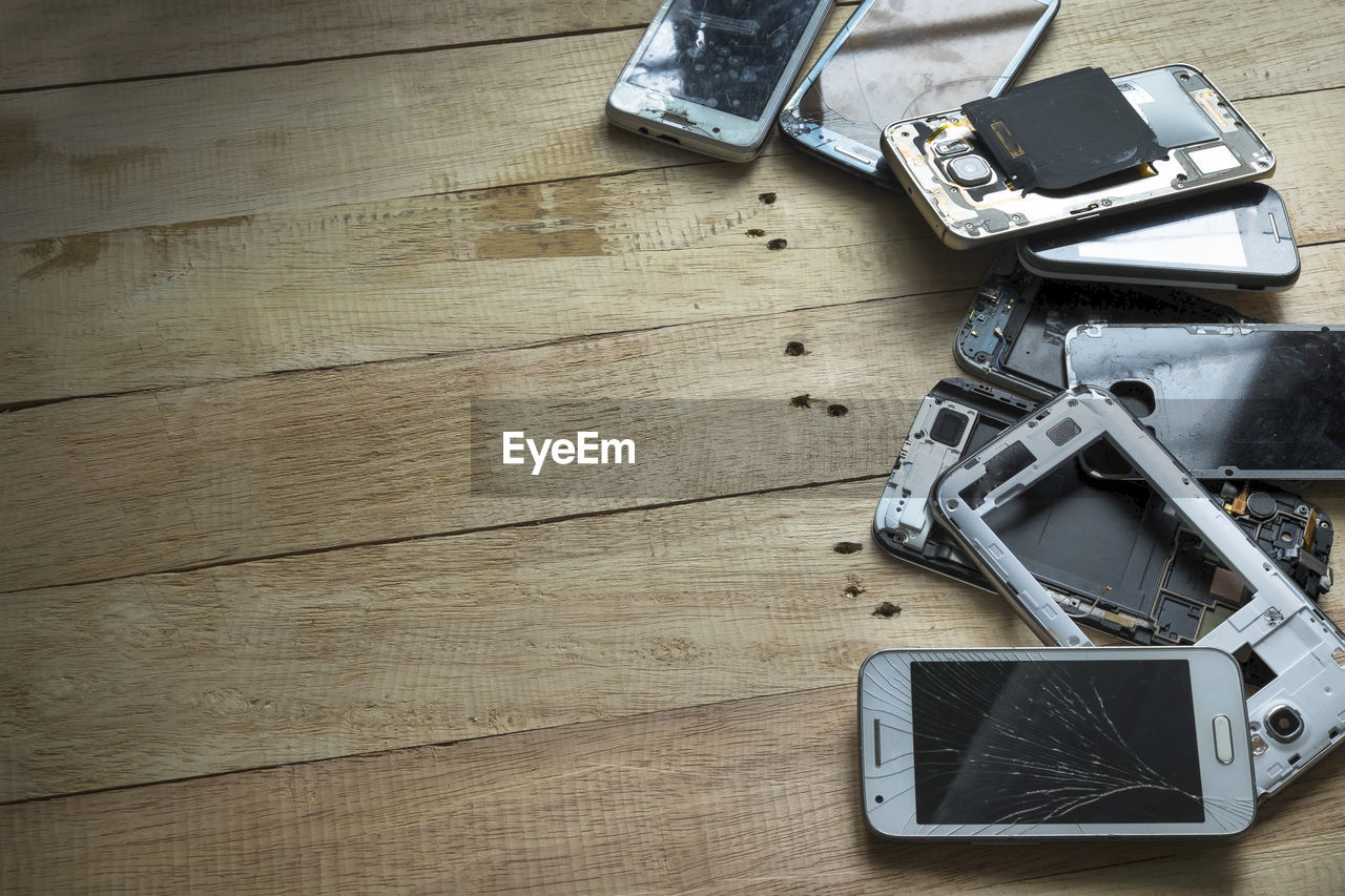 High angle view of damaged smart phone on wooden table