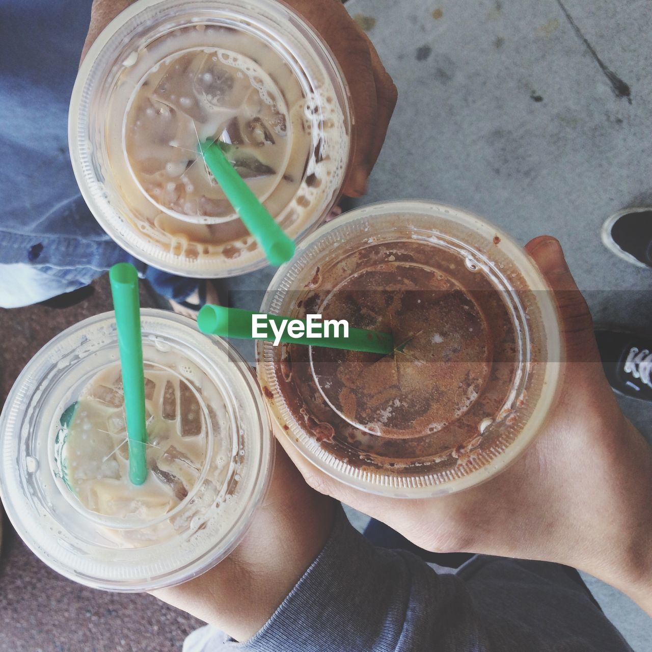 Cropped image of people holding drink in disposable cup