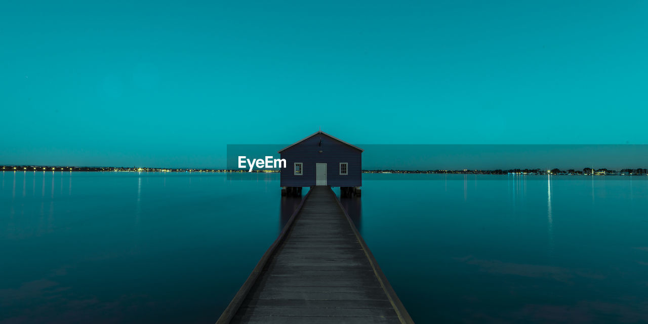 Pier over lake against blue sky