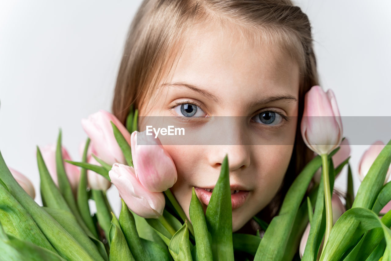 PORTRAIT OF CUTE GIRL WITH PINK FLOWER