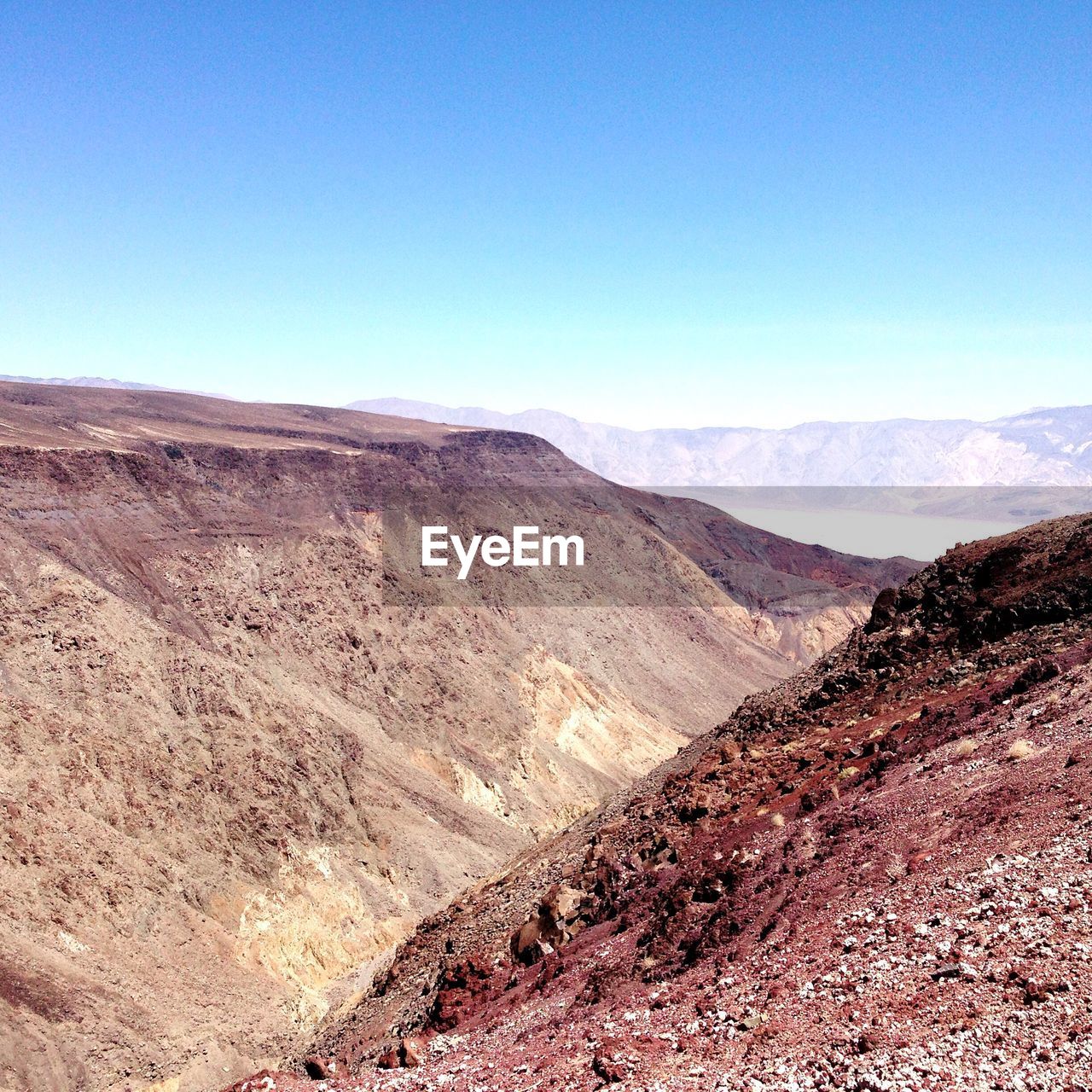 Scenic view of desert against clear blue sky