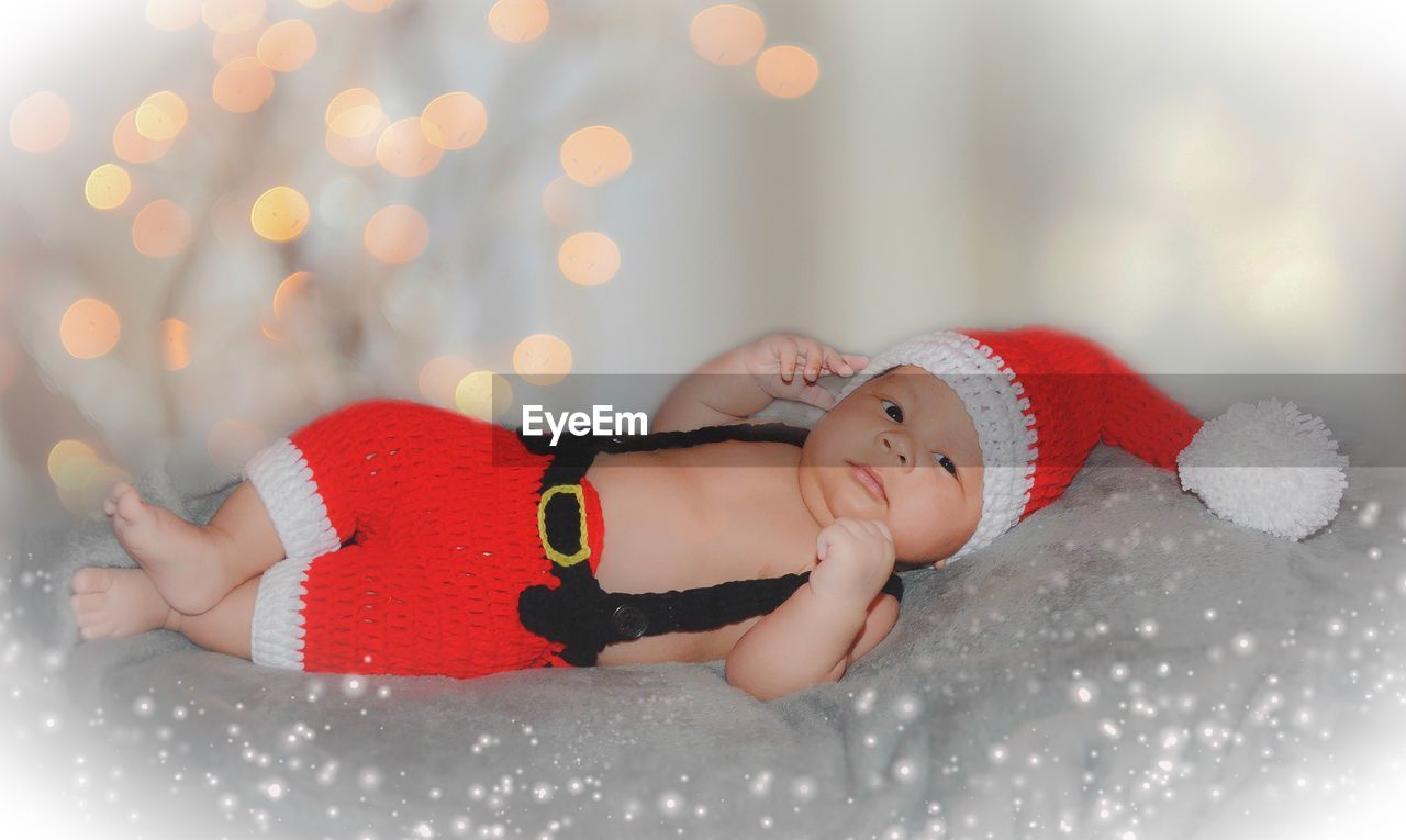 Full length of cute baby lying on blanket during christmas