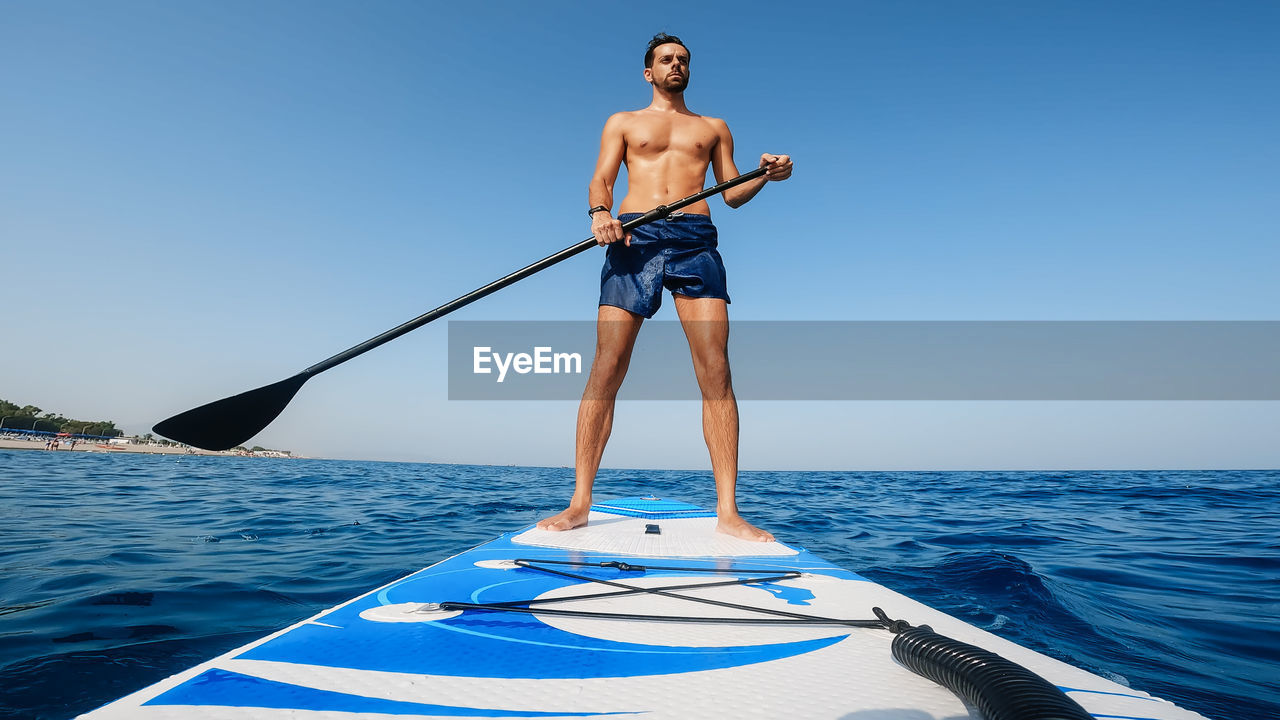 Man on stand up paddle.