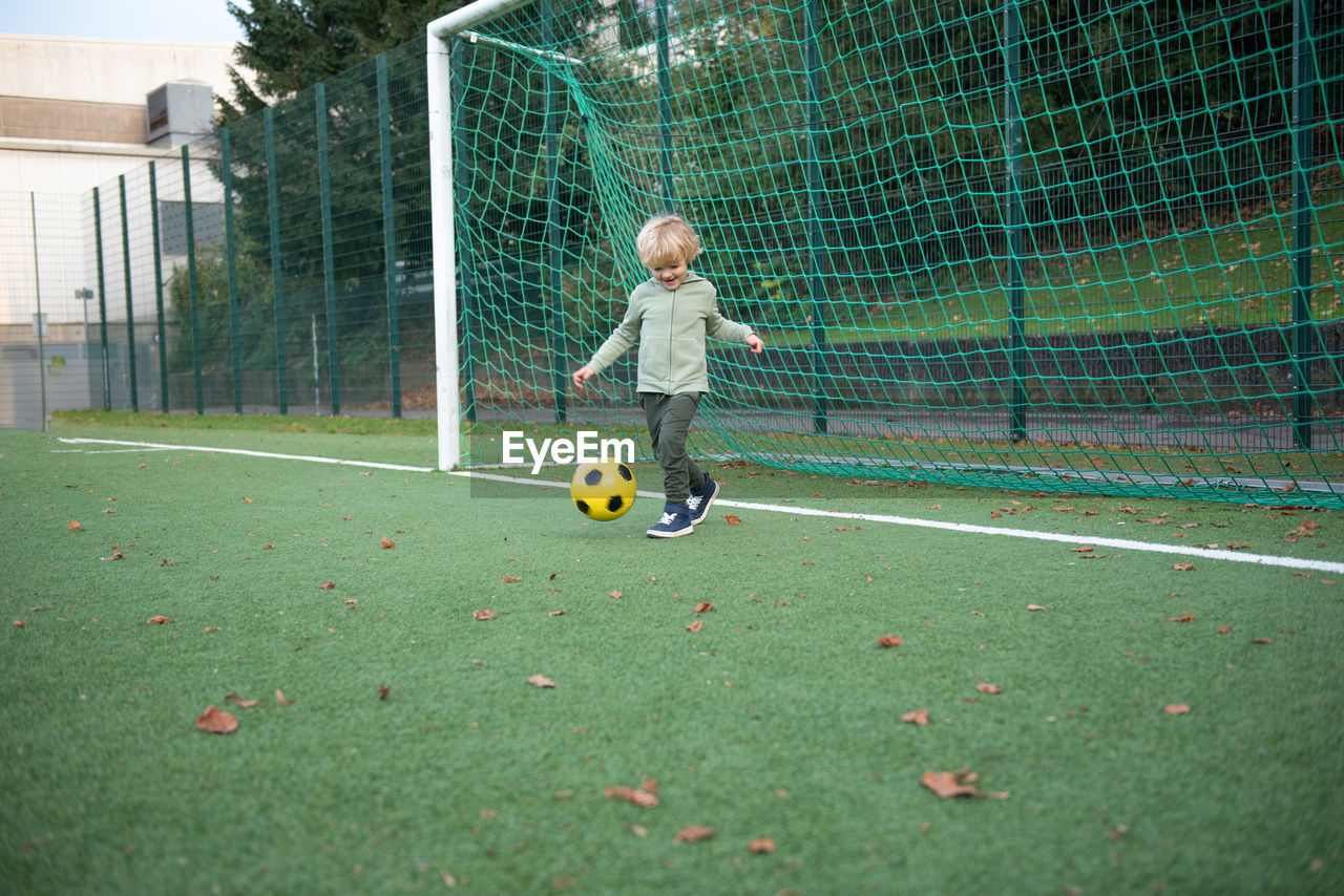 A little boy plays soccer on the soccer field