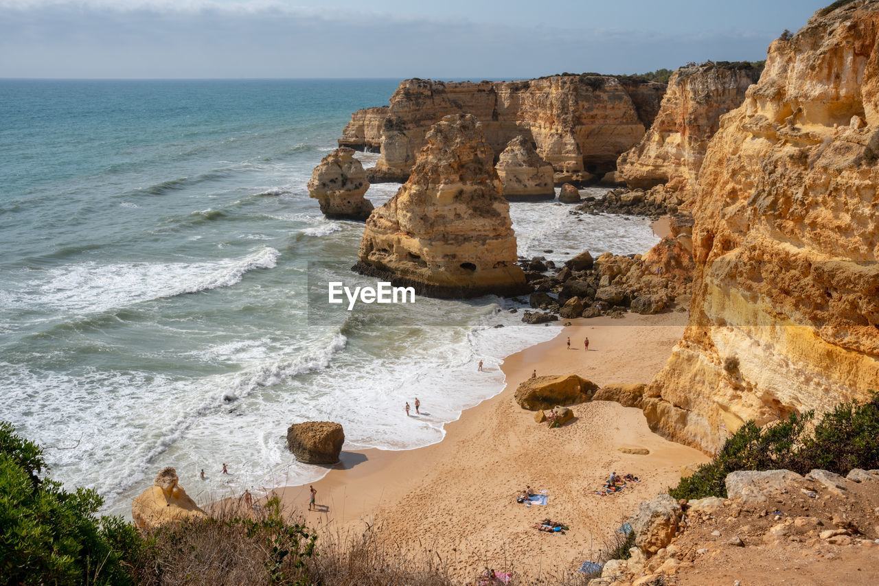 sea, land, water, rock, beach, beauty in nature, scenics - nature, cliff, sky, nature, rock formation, coast, shore, wave, vacation, motion, terrain, ocean, body of water, horizon, horizon over water, travel destinations, sports, coastline, tranquility, surfing, water sports, day, tranquil scene, travel, sand, outdoors, non-urban scene, geology, idyllic, bay, landscape, environment, tourism