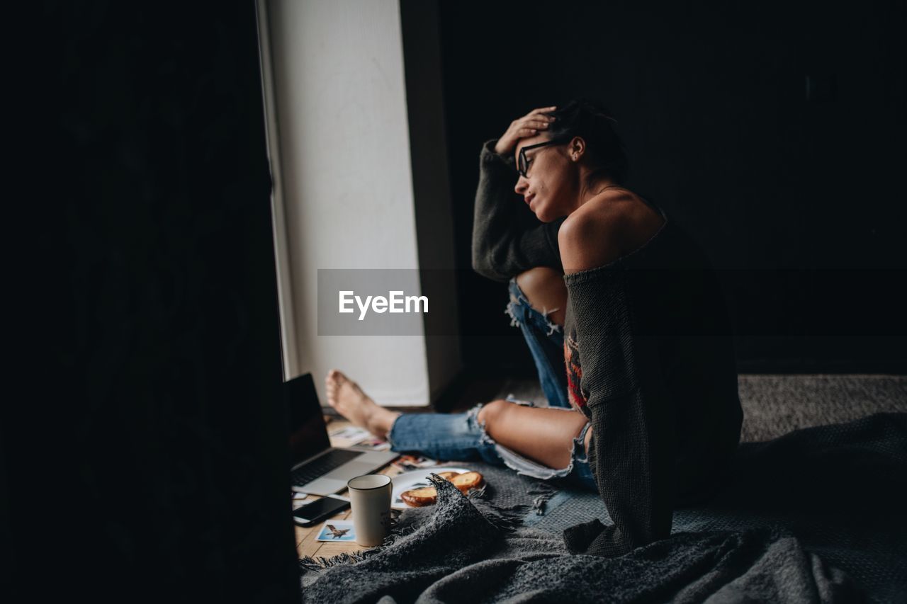 Thoughtful woman siting at home