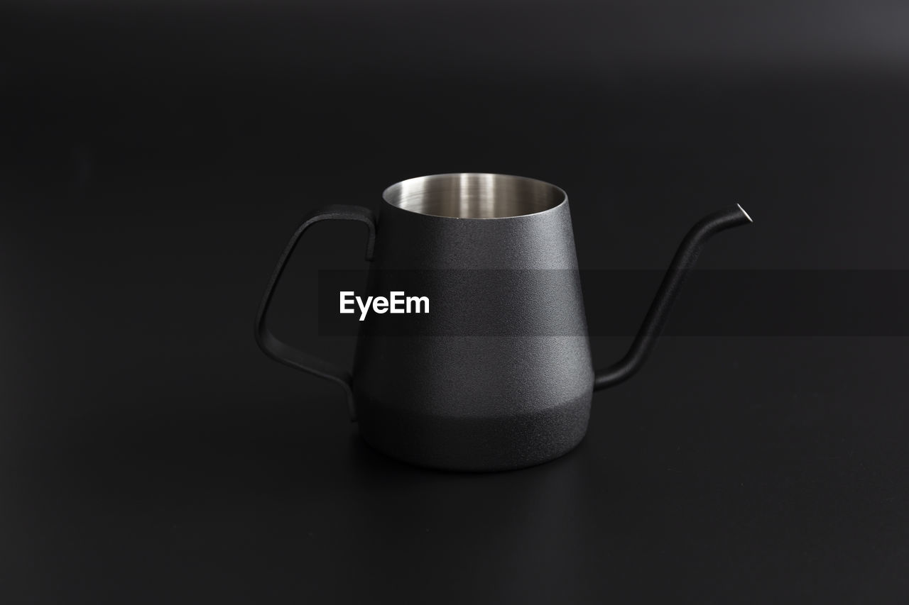 Close-up of coffee cup on table against black background