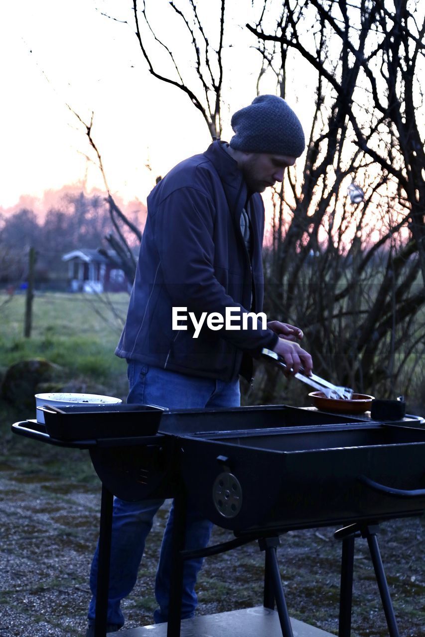 Man standing outdoors by the grill 