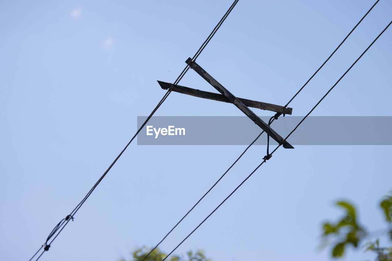 overhead power line, sky, electricity, power generation, technology, nature, cable, line, blue, no people, clear sky, power supply, low angle view, day, outdoors, environment, wind, mast, plant, transmission tower, power line, environmental conservation, tree, electrical supply, sunny, outdoor structure, electronic device, copy space