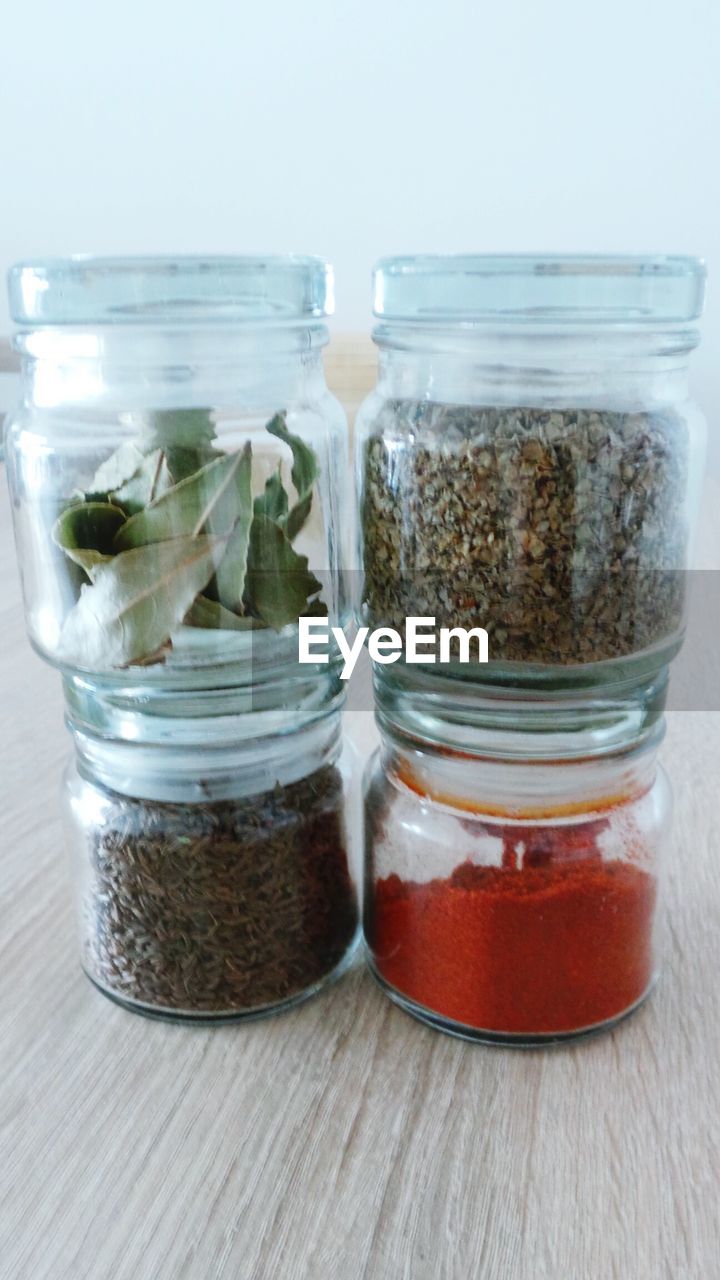 Various spices in glass container on wooden table