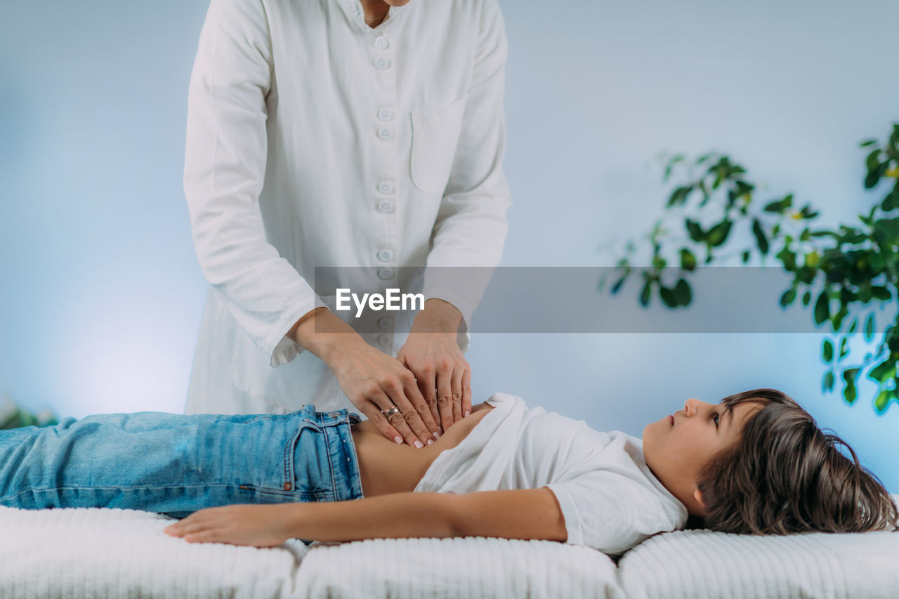 Pediatrician gastroenterologist examining preschooler boys abdomen.