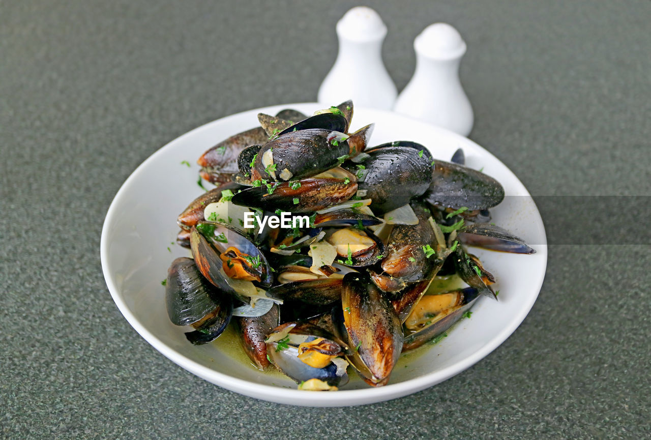 A bowl of moules mariniere or belgian steamed mussels in white wine and garlic