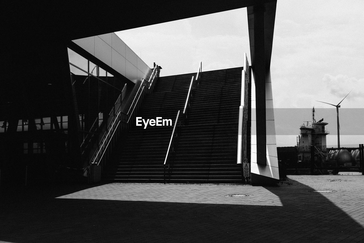 Staircase by modern building against sky