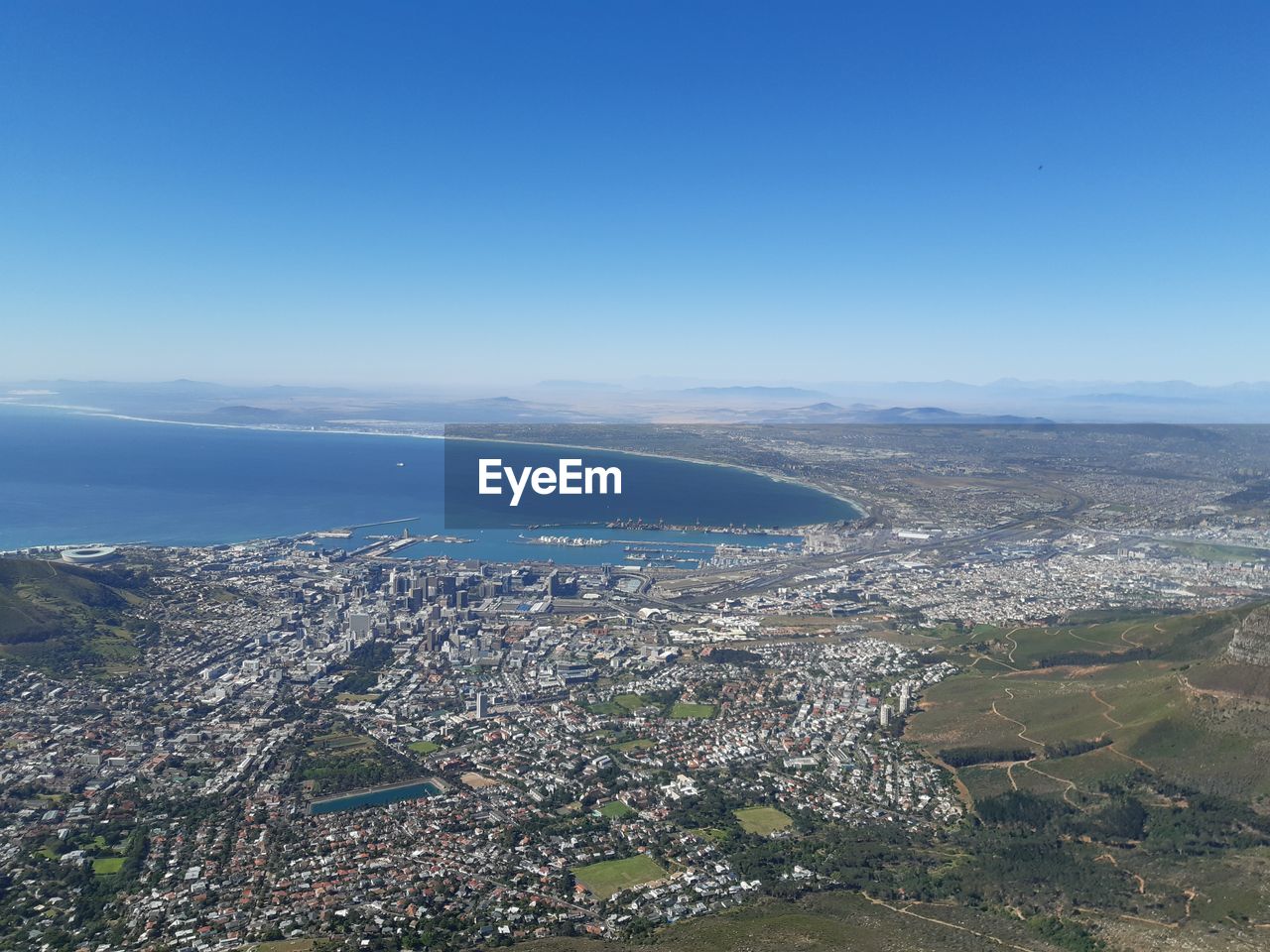 HIGH ANGLE VIEW OF CITYSCAPE BY SEA AGAINST SKY