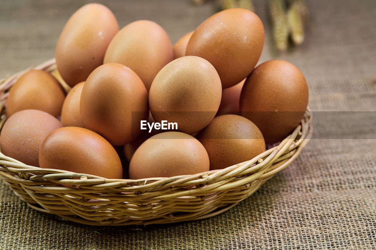 Close-up chicken eggs in a wicker basket isolate on the table