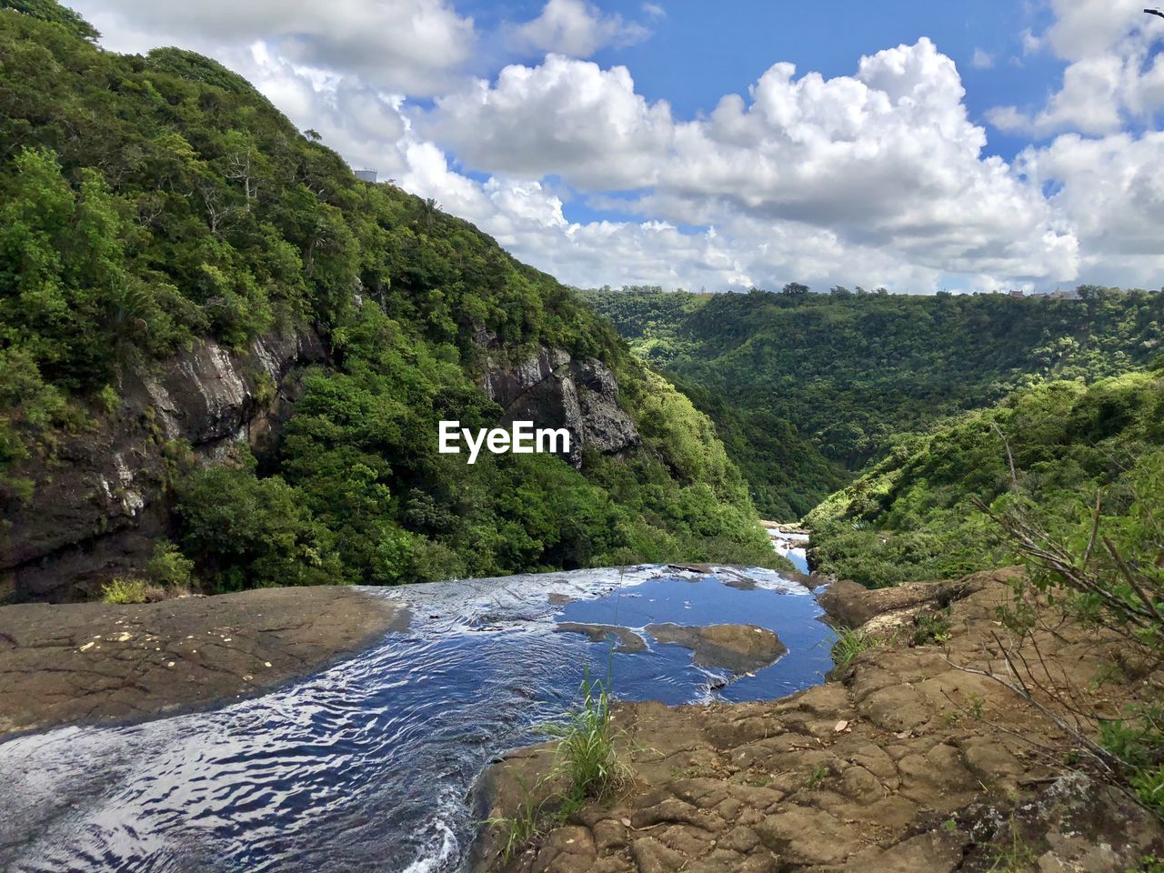 Scenic view of river amidst mountains against sky