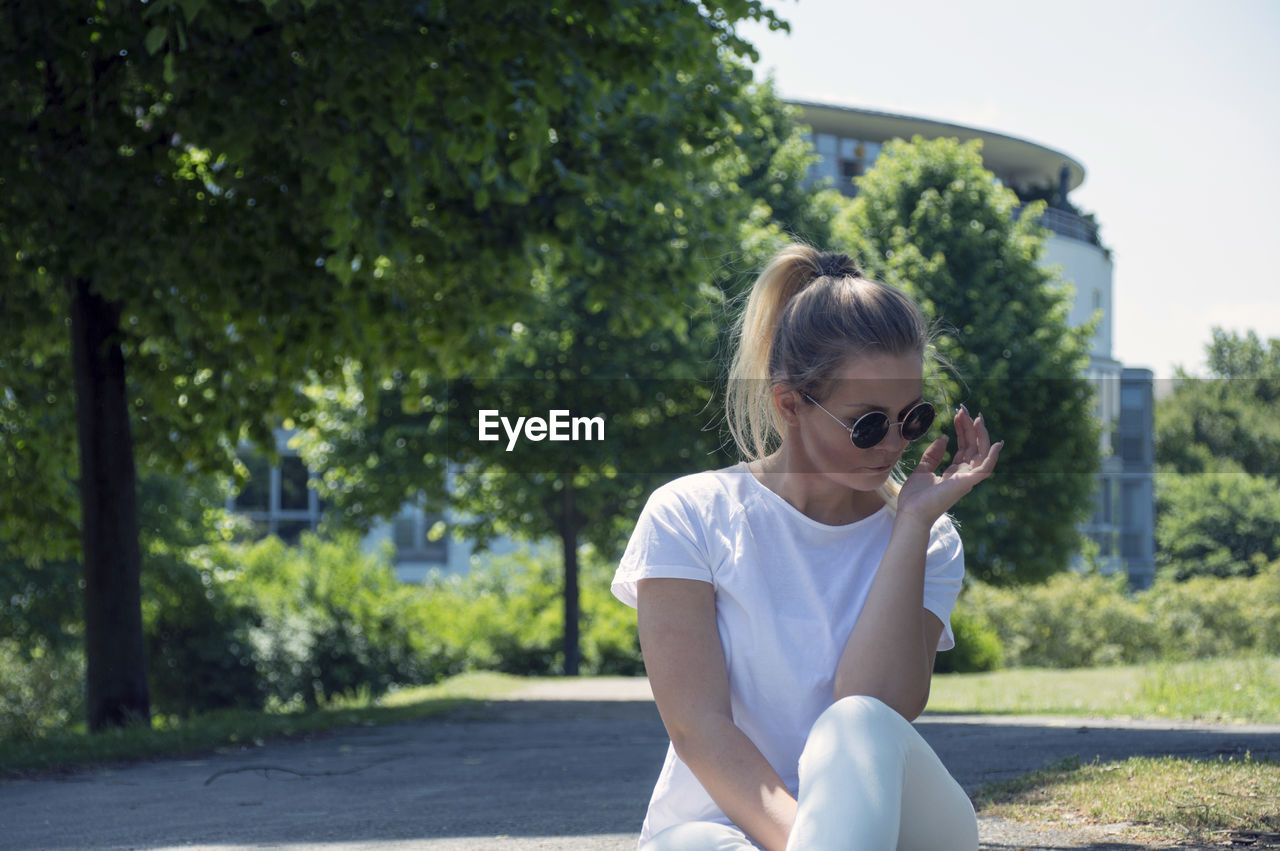 Woman wearing sunglasses sitting on field