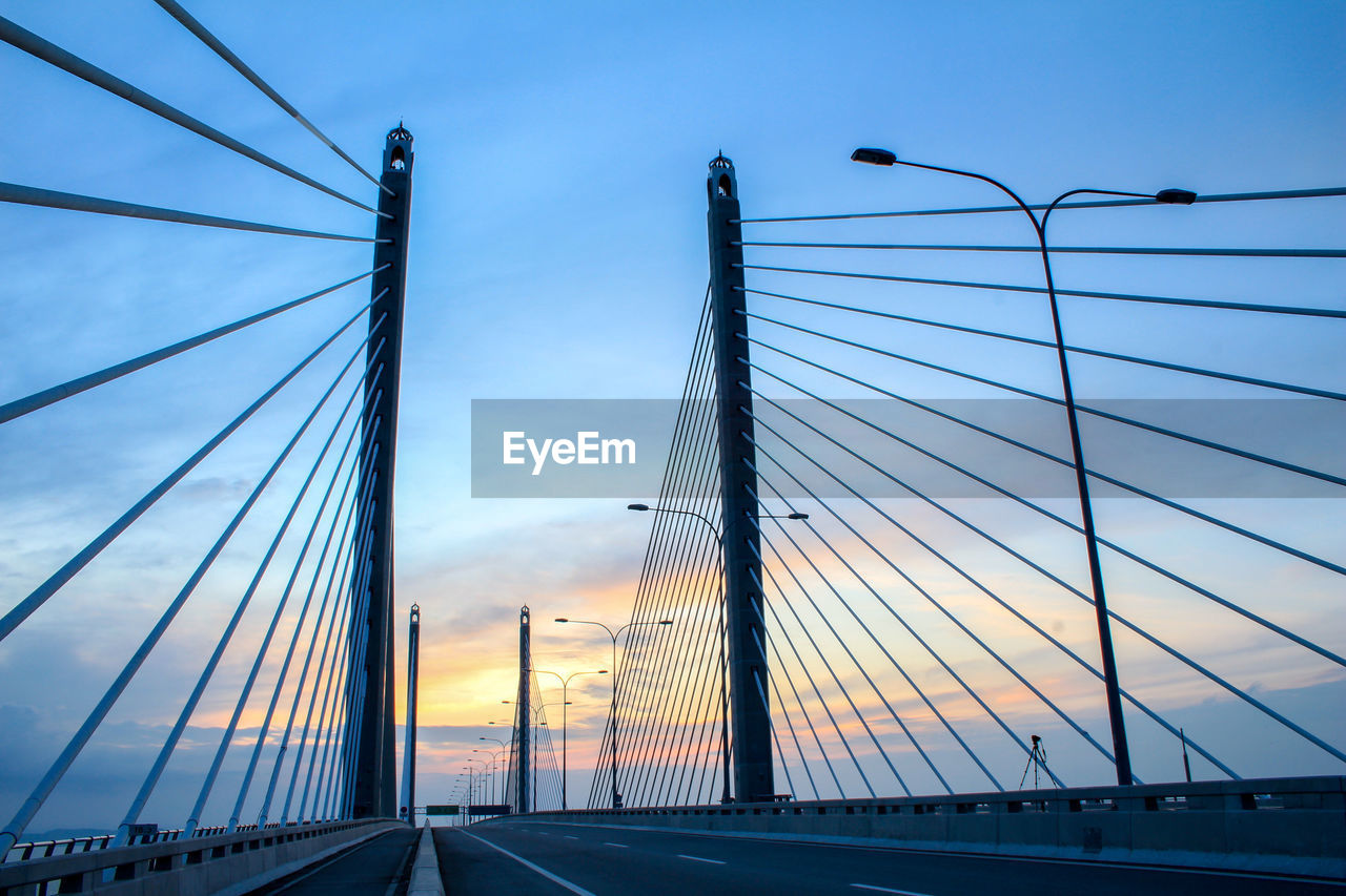 Low angle view of suspension bridge against sky