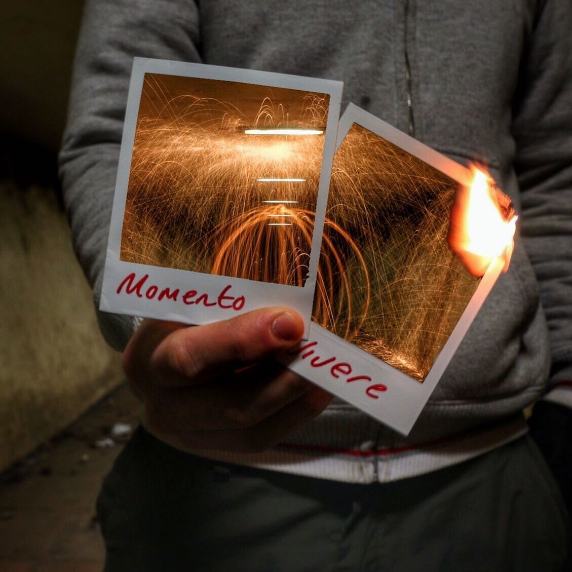 Close-up of hand with burning photographs