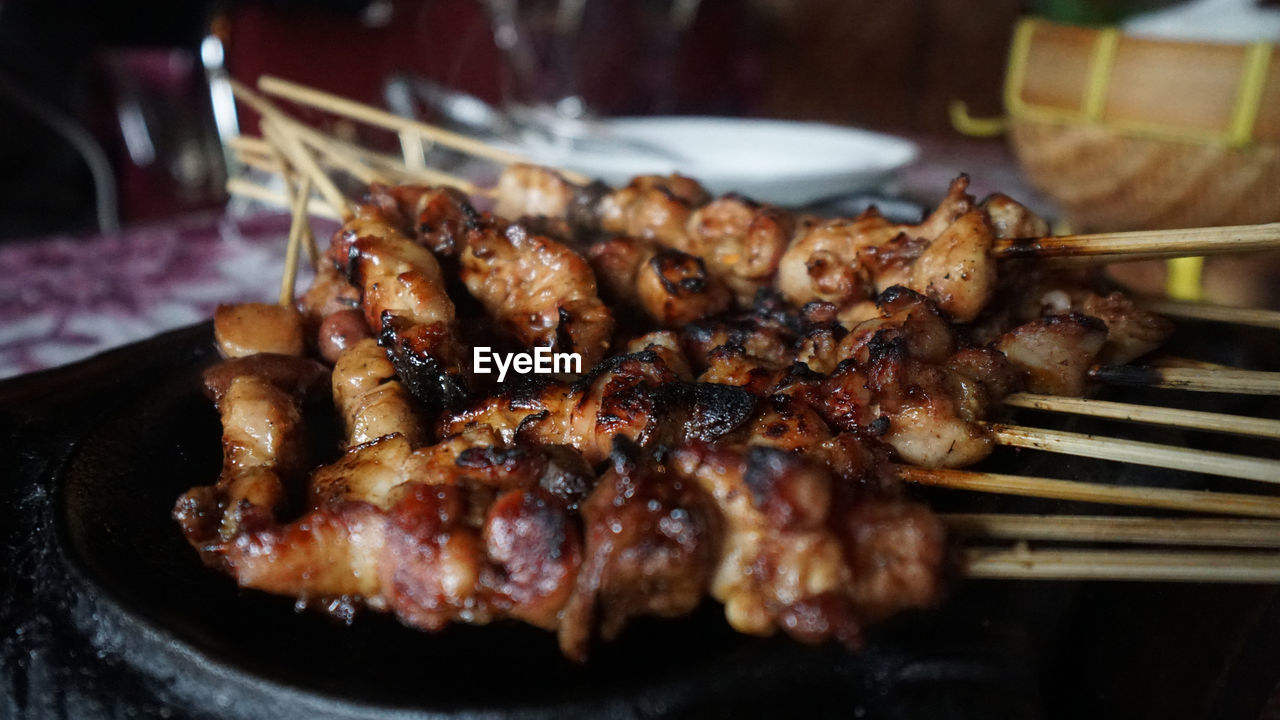 CLOSE-UP OF MEAT COOKING ON BARBECUE GRILL