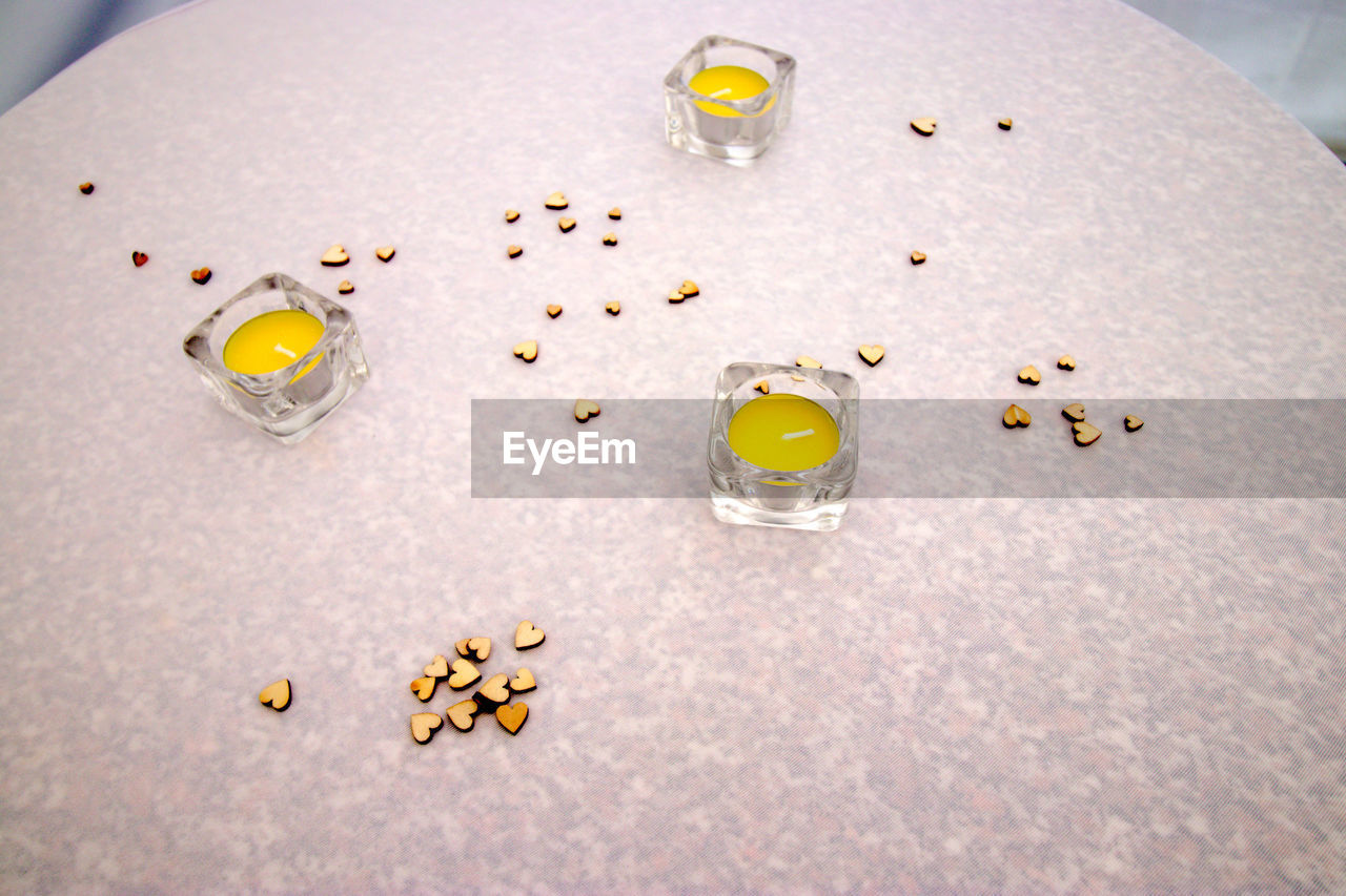 HIGH ANGLE VIEW OF YELLOW AND DRINK ON TABLE