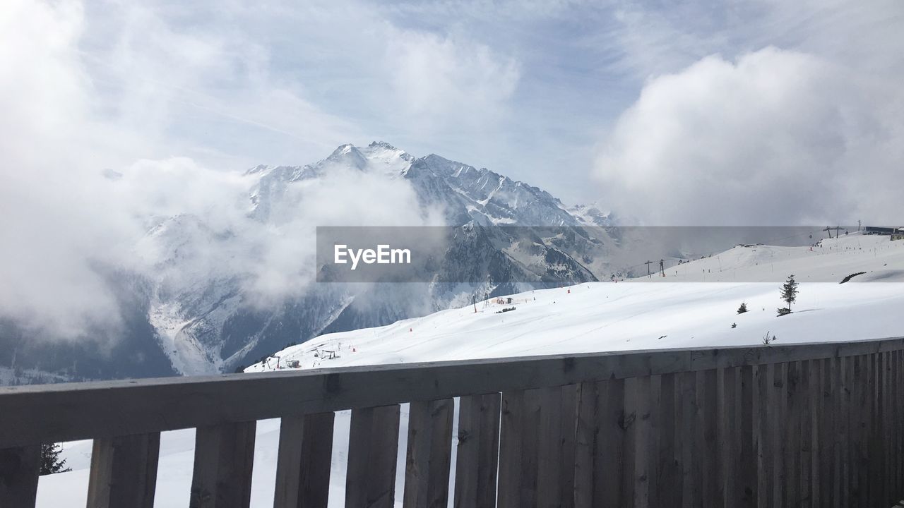 Panoramic view of snow covered mountains against sky