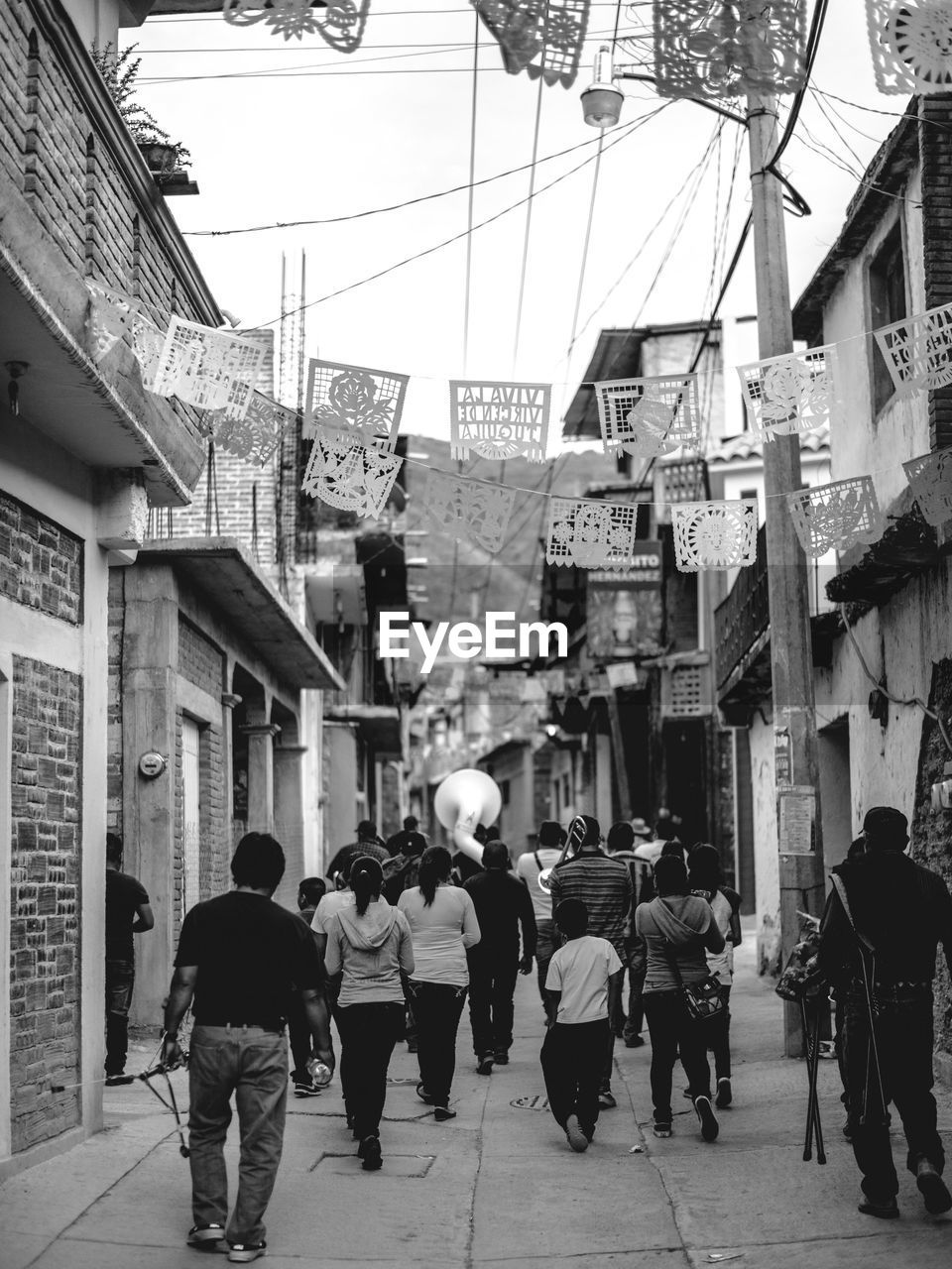 Rear view of people walking on street in city