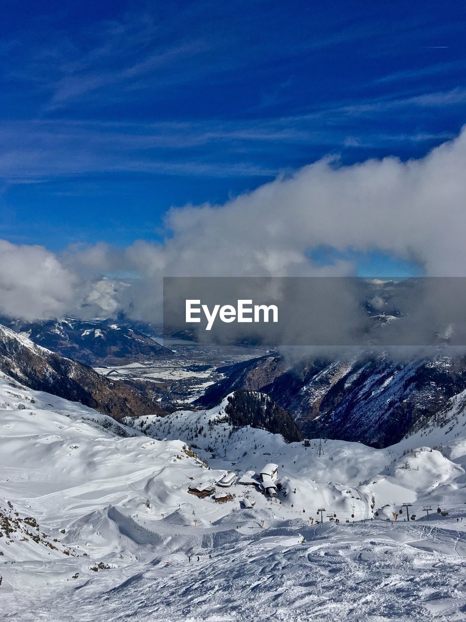 Aerial view of snowcapped mountains against blue sky