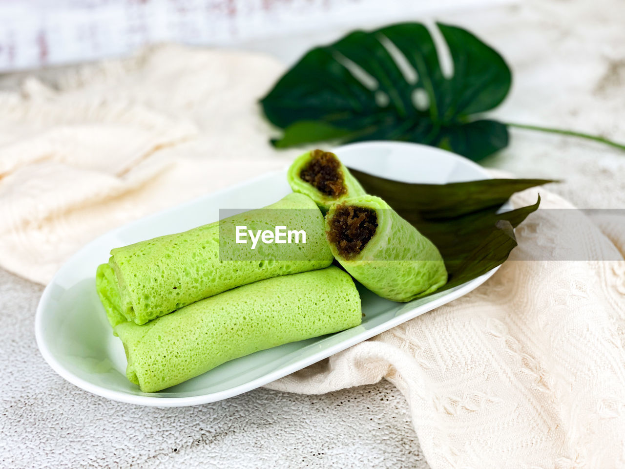 Close-up of green sweet dessert of kuih ketayap on table