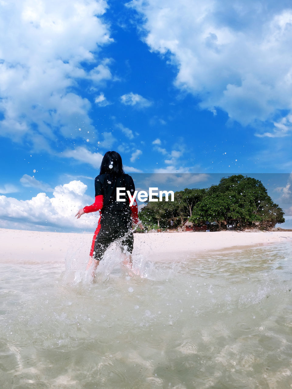 Rear view of man in sea against sky