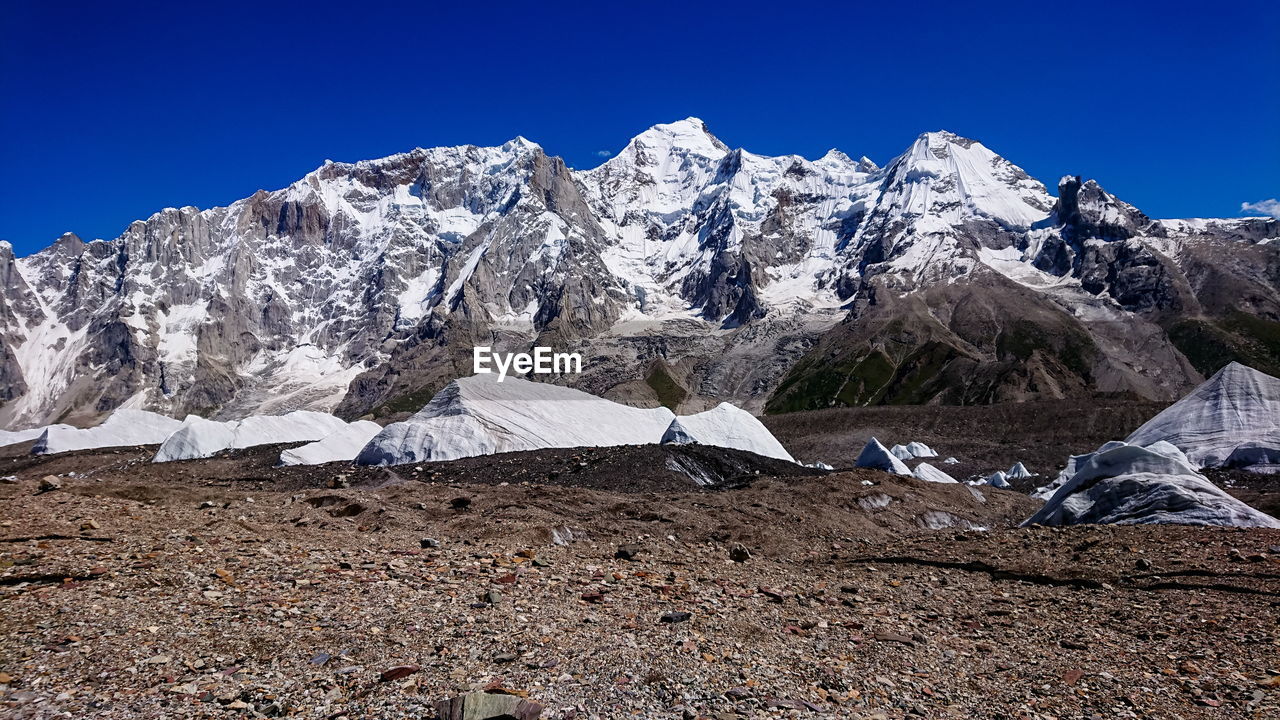 Scenic view of snowcapped mountains against clear blue sky