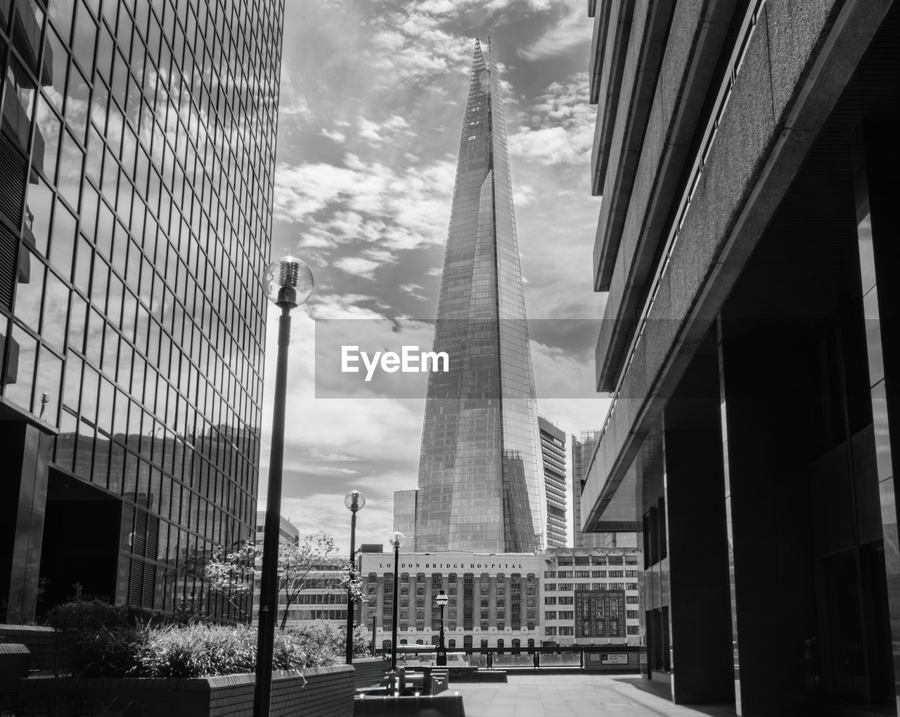 A view of the shard in london taken between two buildings. london bridge hospital is also visible.