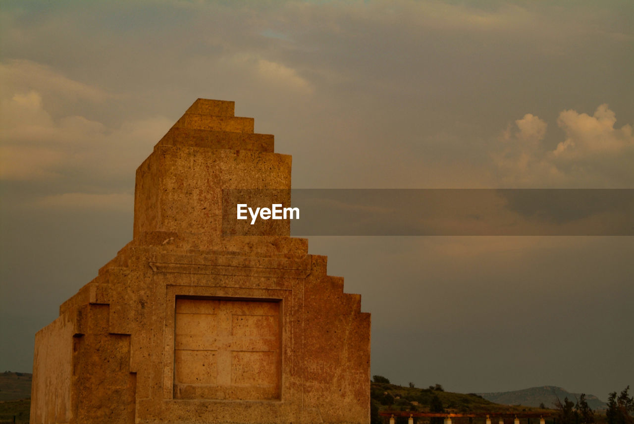 Low angle view of old building against sky during sunset