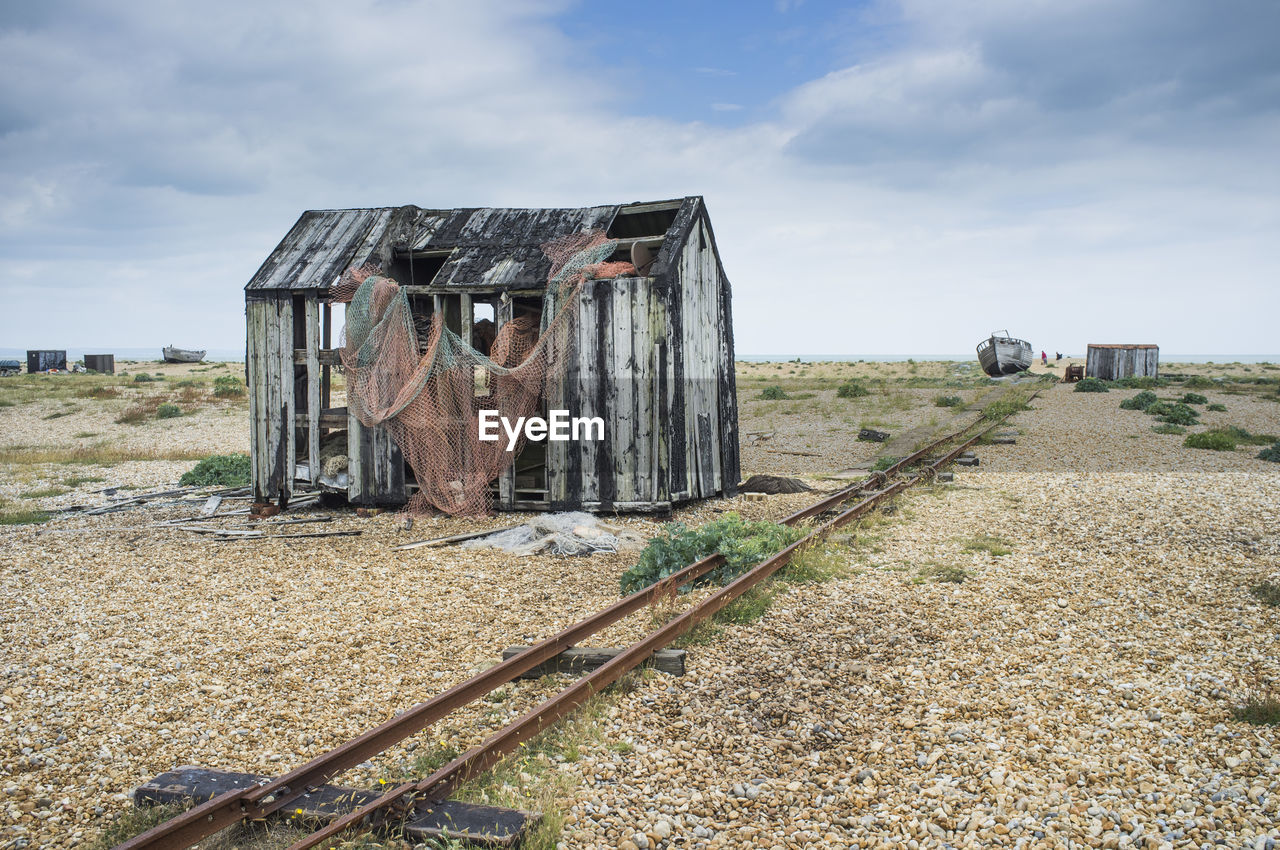 Damaged house at beach against sky