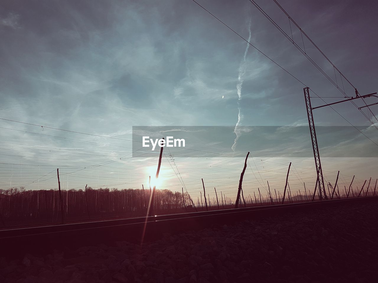 WET ELECTRICITY PYLON AGAINST SKY DURING SUNSET