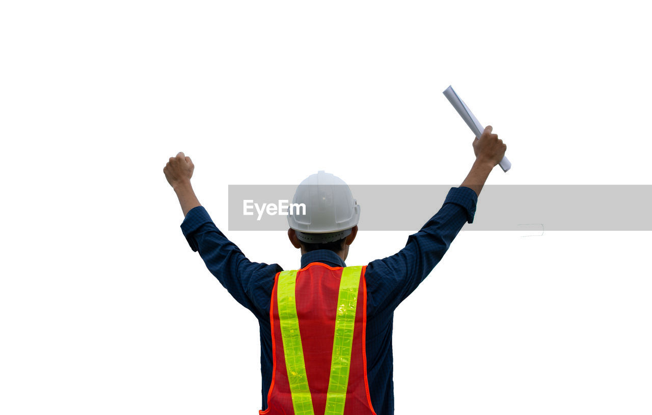 REAR VIEW OF PERSON STANDING WITH ARMS RAISED