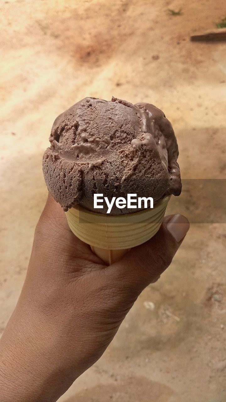 CLOSE-UP OF WOMAN HAND HOLDING ICE CREAM