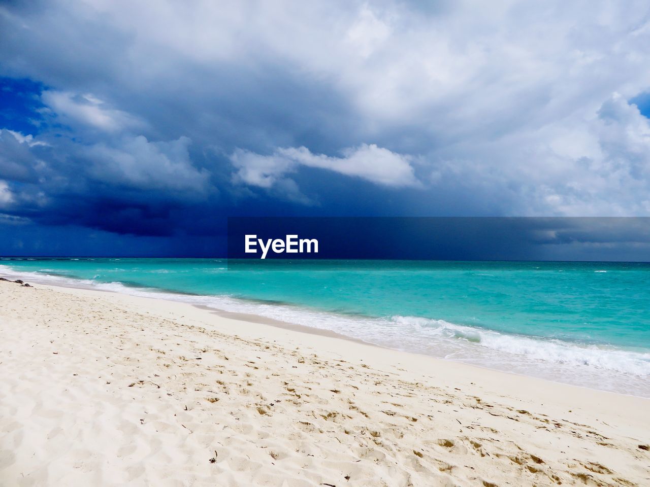 SCENIC VIEW OF SEA AGAINST CLOUDY SKY AT DUSK