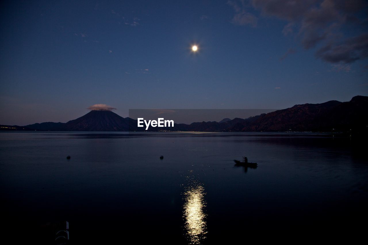 Scenic view of lake against sky at night