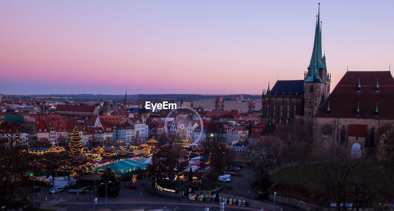 HIGH ANGLE SHOT OF ILLUMINATED CITYSCAPE AGAINST SKY