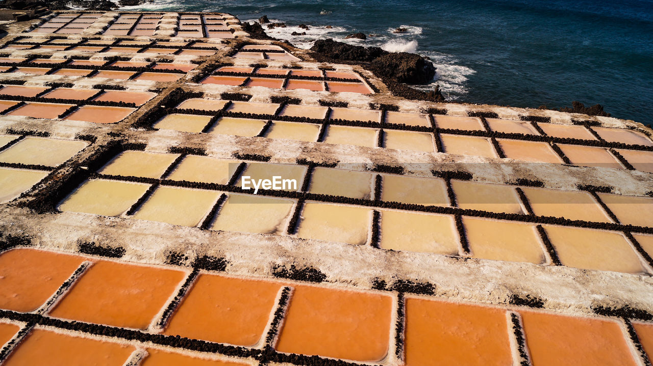 High angle view of salt flat sea salk farm water fields multicolour texture background 