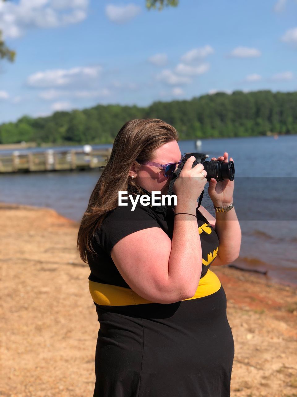 MIDSECTION OF WOMAN PHOTOGRAPHING WITH CAMERA