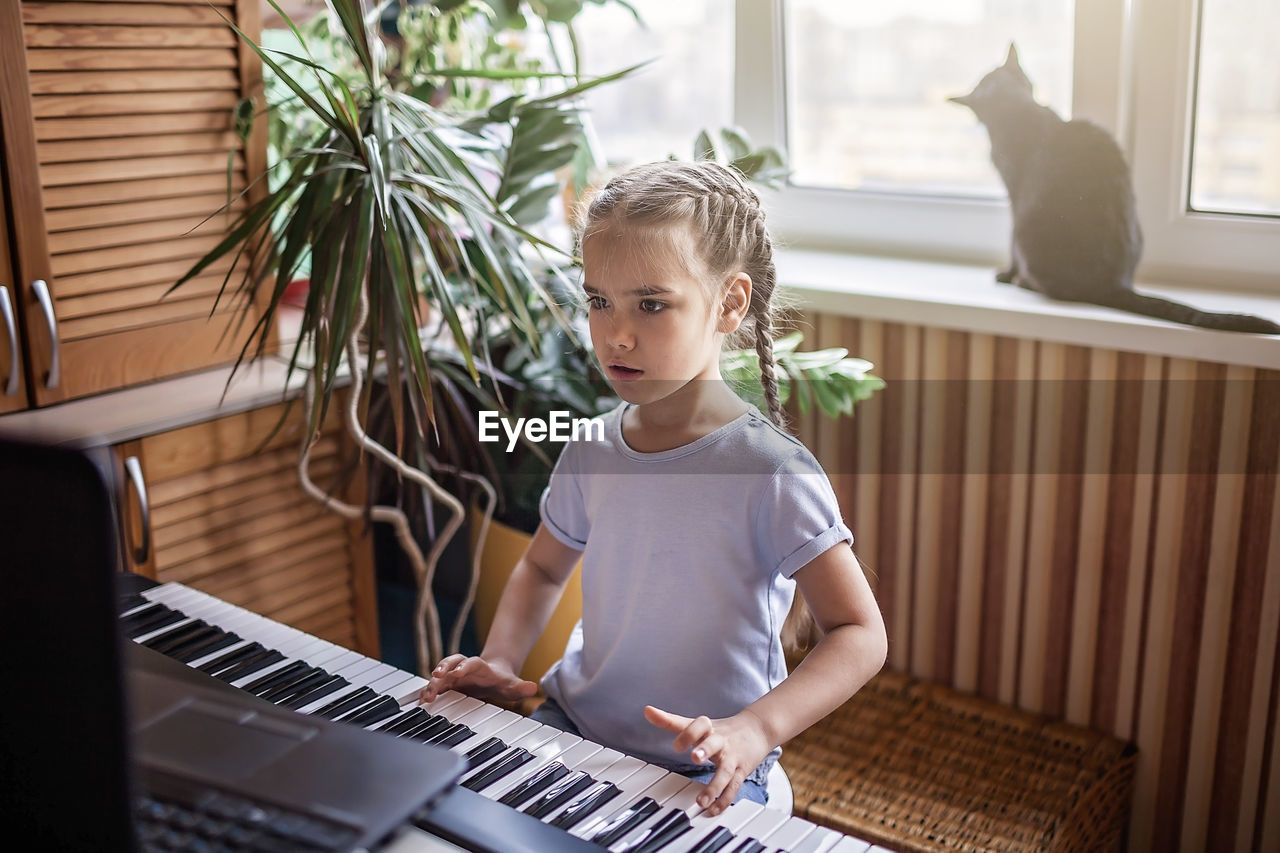 FULL LENGTH OF A BOY PLAYING WITH PIANO