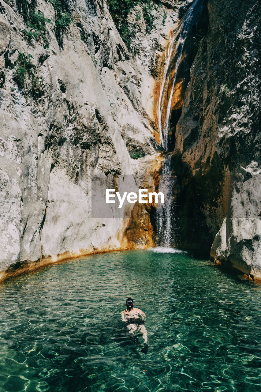 Girl in the water in a waterfall in sadernes, catalonia