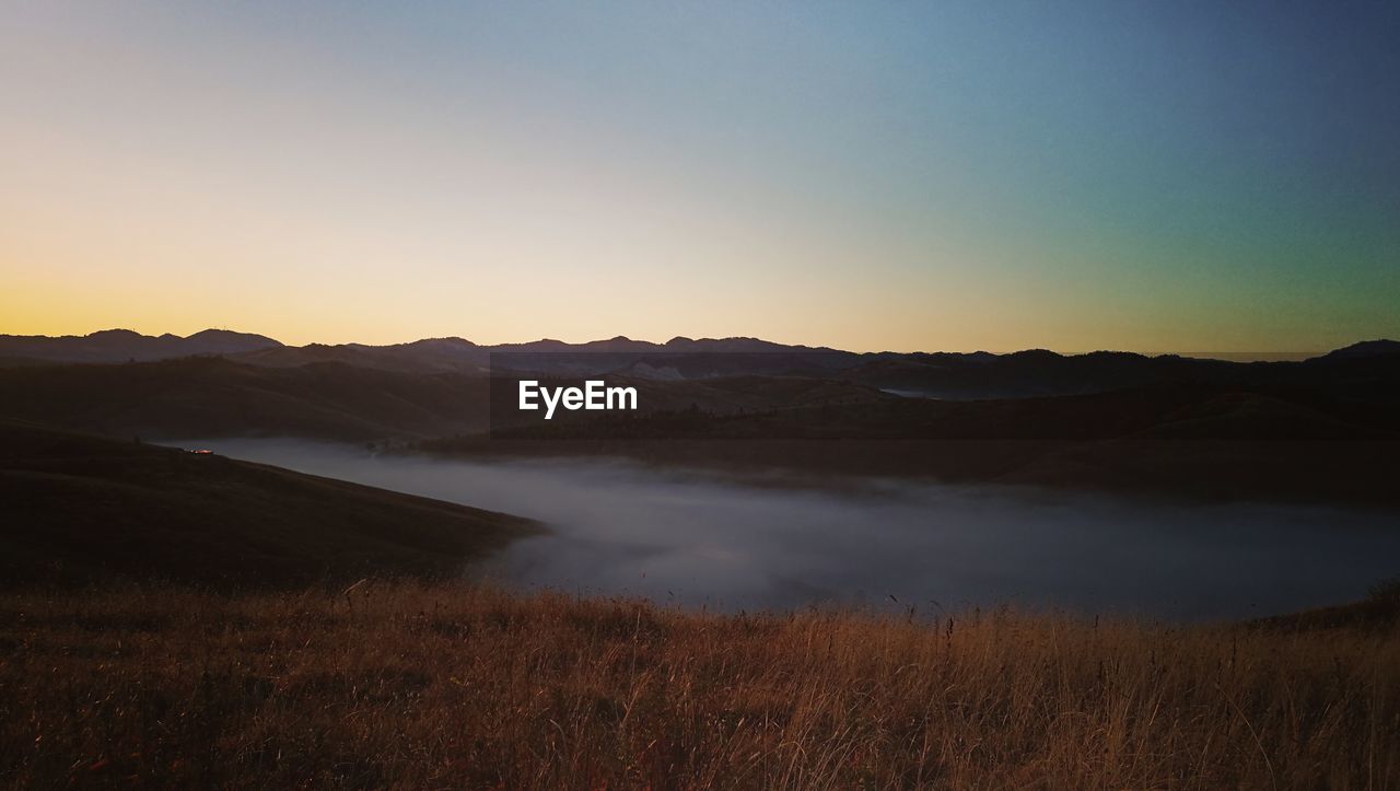 SCENIC VIEW OF SILHOUETTE MOUNTAIN AGAINST SKY