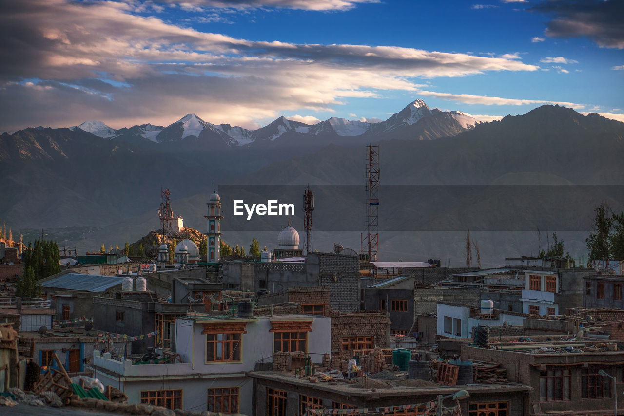 View of cityscape against cloudy sky