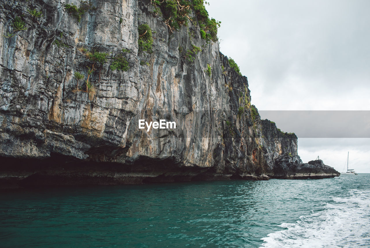 Rock formation in sea against sky